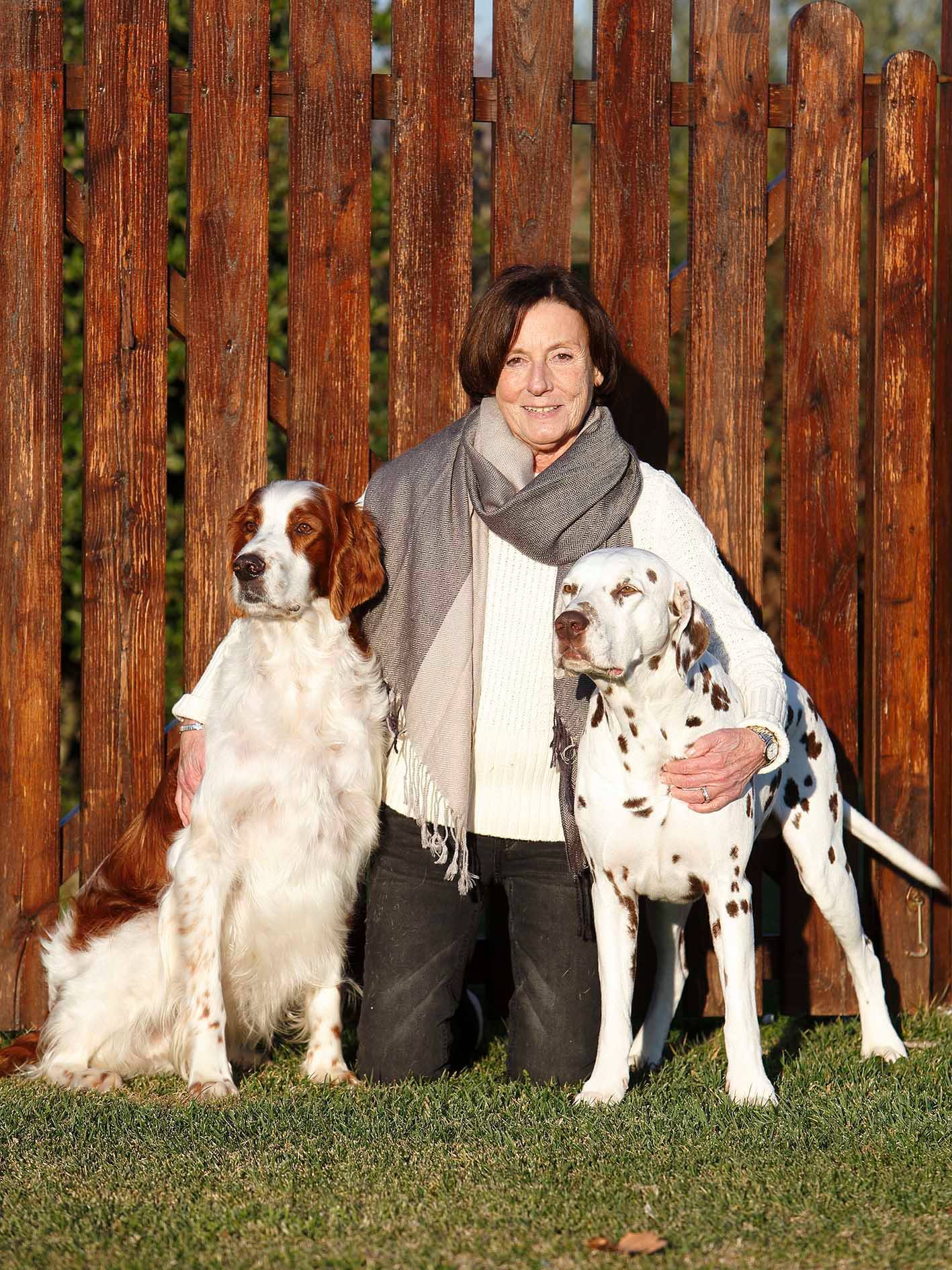 Fiorella smiling outdoors with two dogs